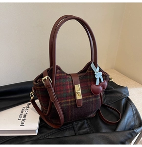 Détail du sac cabas vintage en laine à carreaux avec fermoir doré et accessoire cerise