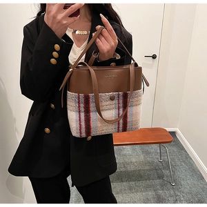 Détail du patchwork en cuir marron et tissu à carreaux sur un sac à main rétro