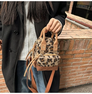 Dettaglio borsa peluche leopardata con finiture in velluto a coste e zip dorate
