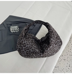 Detailed close-up of the leopard print suede hobo bag texture and seamless handle design