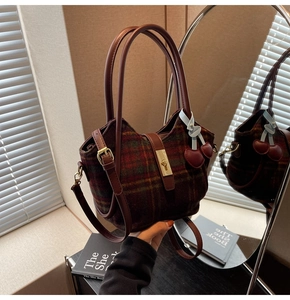 Détail du sac cabas à carreaux rouge et vert avec fermoir doré et accessoire cerise