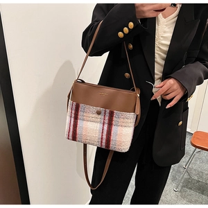 Détail d'un sac à bandoulière vintage en tweed multicolore et simili cuir marron poli