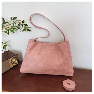 Close-up of pink suede Boston bag with vintage brass hardware in a retro interior