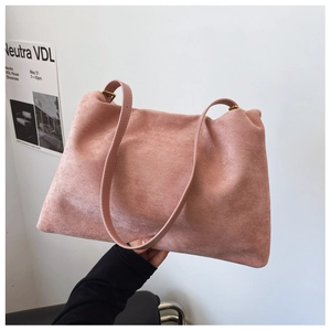 Detail of pink suede Boston bag with smooth leather straps and antique bronze hardware