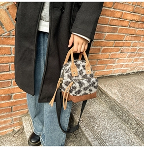 Dettaglio della borsa in peluche leopardata con finiture in velluto e zip con lunghe nappe
