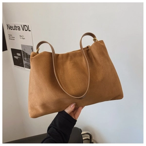 Detail of a brown suede Boston bag showing soft pleats and thin leather straps