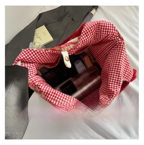 Detail view of red plaid tote bag interior showing large capacity with makeup products