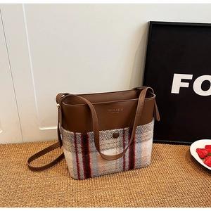 Détail du mélange vintage de cuir marron et de tissu en laine à carreaux sur le sac