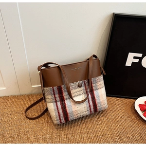 Détail du sac bandoulière vintage en cuir marron et tissu de laine à carreaux rouges