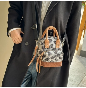 Dettaglio della mini borsa in peluche leopardata indossata su un cappotto nero invernale