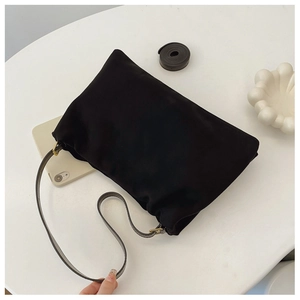 Top view of a black soft shoulder bag with gold hardware and leather strap detail