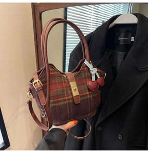 Détails d'un sac cabas vintage en laine à carreaux avec fermoir doré et pendentif cœur