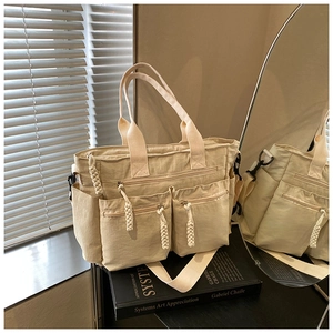 Detail view of beige canvas tote with functional multi-pockets and detachable wide strap