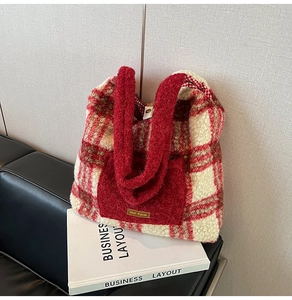 Detail of red and white plaid plush tote bag with front pocket and metal nameplate