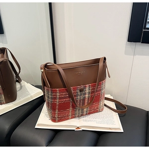 Détail d'un sac patchwork rétro en cuir marron et tissu de laine à carreaux rouges