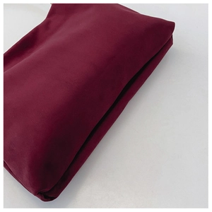 Detail view of the burgundy suede Boston bag showing the side fold and soft texture