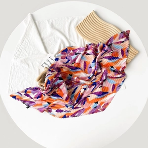Pleated silk scarf for women featuring abstract orange and purple floral print patterns