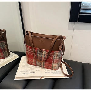 Détail d'un sac à bandoulière vintage en cuir marron et tissu à carreaux texturé