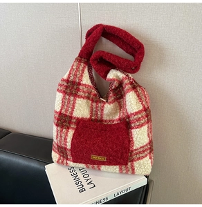 Detail of red and white plaid plush tote bag with furry pocket and gold lettering decoration