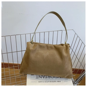 Detail of khaki suede shoulder bag featuring gold ring hardware and premium texture