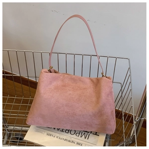 Detailed shot of pink suede Boston bag featuring vintage gold hardware in a shopping cart