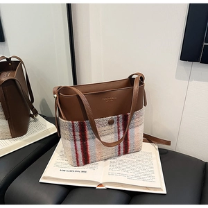 Détail du cabas en tweed et cuir marron avec texture vintage et lettrage de marque