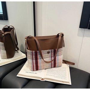 Détail du sac seau grande capacité en cuir marron et tissu à carreaux avec bandoulière