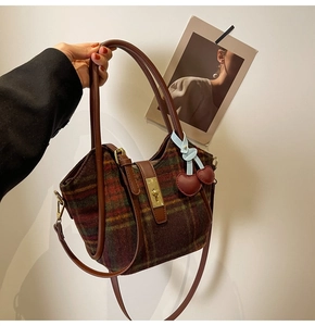 Gros plan du sac en laine à carreaux vintage avec bordure en cuir brun et fermoir