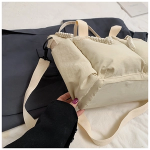 Detailed view of beige nylon tote bag with multiple pockets and woven rope handles