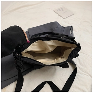 Detail shot of the black tote bag interior with beige lining and a zipper pocket