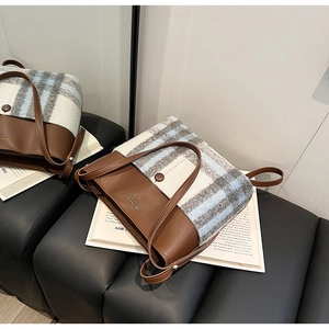Détail du sac à bandoulière vintage en cuir marron et tweed à carreaux bleus et gris