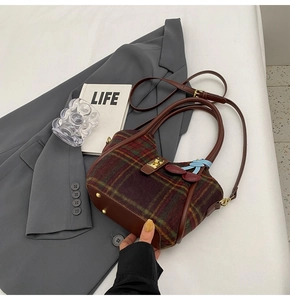 Vue détaillée du sac cabas rétro en laine à carreaux avec poignées en cuir et cerise