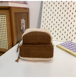 Dettaglio del velluto a coste marrone e tessuto peluche bianco sporco dello zaino
