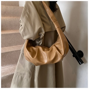 Close-up of caramel soft leather hobo bag showing pleated texture and cloud shape