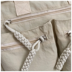 Macro view of beige nylon tote fabric texture with durable zippers and woven pullers