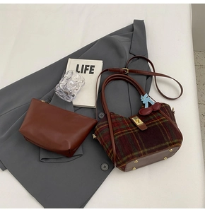 Détail du sac cabas en laine à carreaux et pochette en cuir avec breloque cerise