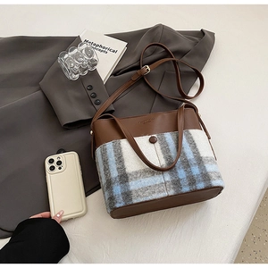 Détail du sac seau rétro avec cuir marron et textures en tissu à carreaux bleu-gris