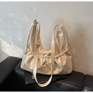 Detailaufnahme der beigen Leder-Schultertasche mit Falten-Design und verstellbarem Gurt