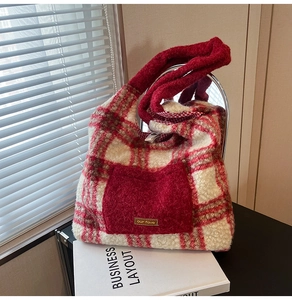 Detailed macro shot of a red plush tote bag with a checkered pattern and fuzzy front pocket