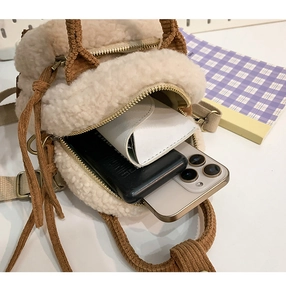Dettaglio della capacità interna della borsa in peluche con smartphone e occhiali