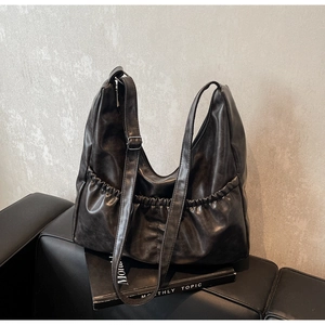 Detail der schwarzen Hobo-Tasche aus Kunstleder mit Falten und verstellbarem Riemen