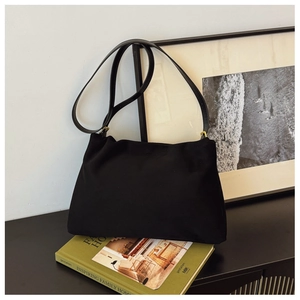 Detail of black nylon Boston bag with gold hardware and slim shoulder strap