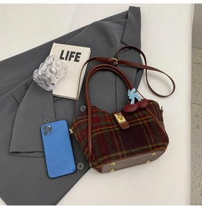 Détail du sac cabas en laine à carreaux avec fermoir métallique et breloques décoratives