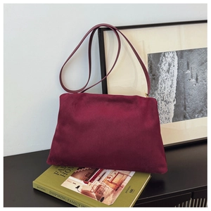 Detail view of burgundy matte suede texture on minimalist vintage Boston pillow bag