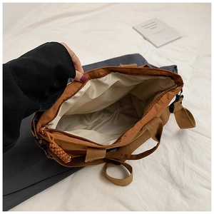 Top view showing large interior storage space and zipper of brown nylon tote bag