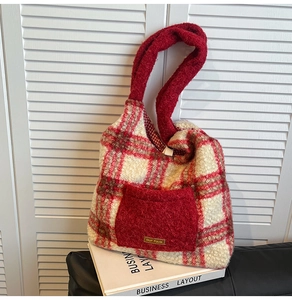 Detail view of red plaid tote bag with fuzzy pocket and our fave decorative label