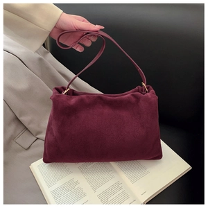 Detail view of burgundy suede texture on a vintage Boston bag with gold hardware