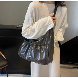 Detail der grauen Hobo-Tasche mit Raffung aus weichem Kunstleder im urbanen Stil