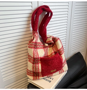 Detail of red plaid plush tote bag with a fuzzy front pocket and our fave fabric label