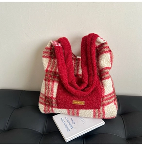 Detail of red and white plaid fuzzy tote bag with textured fleece and leather brand patch